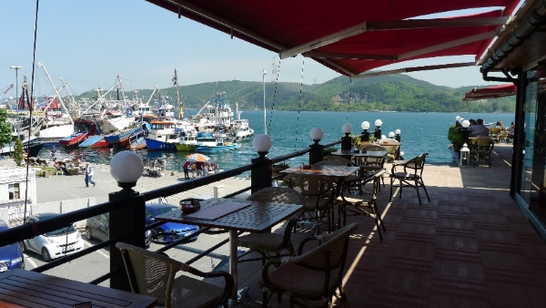 Café am Hafen, im Hintergrund das Meer
