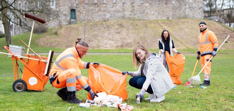 Four people tidy up a meadow
