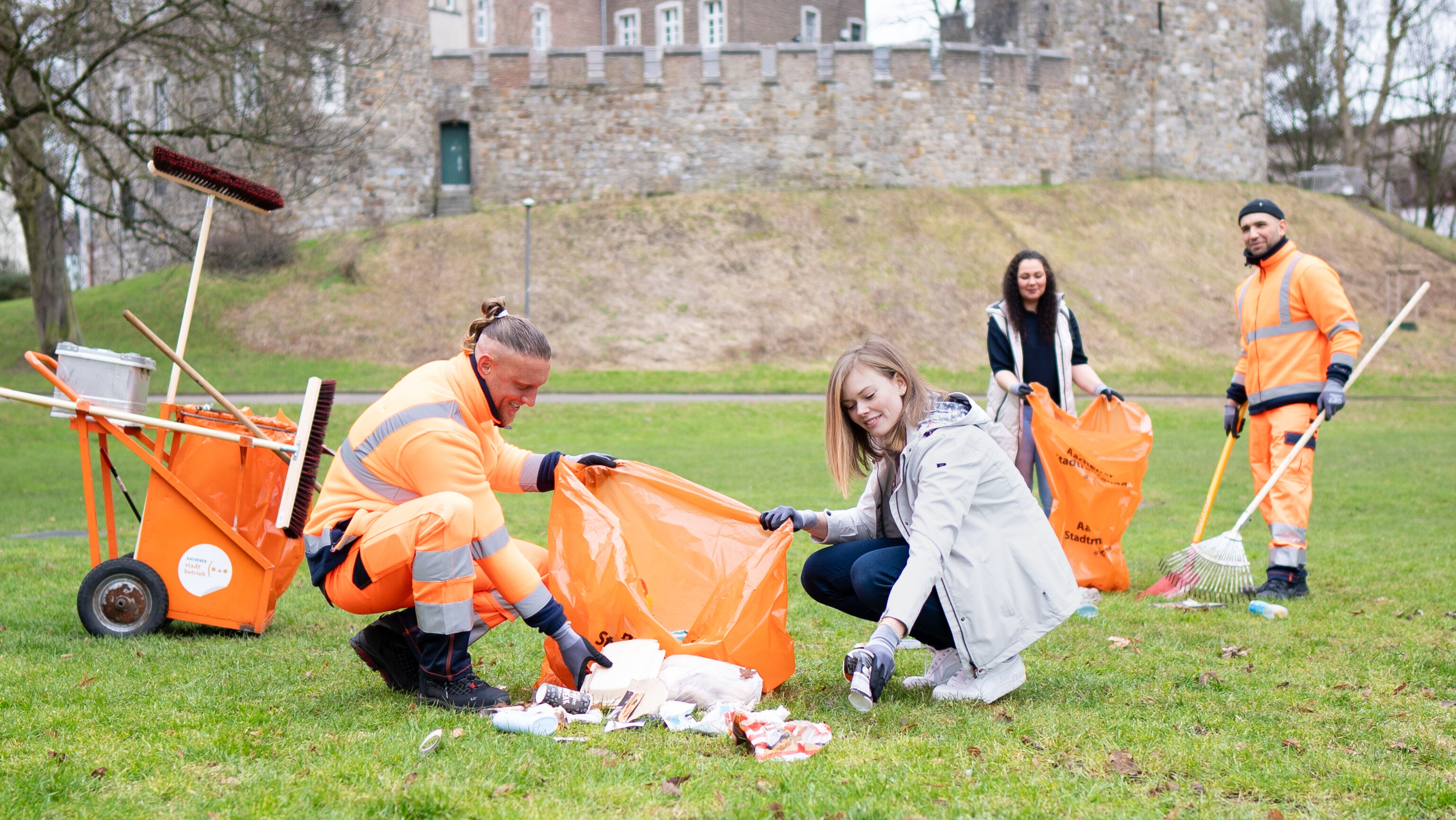 Four people tidy up a meadow