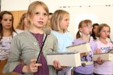 A group of children each play a xylophone
