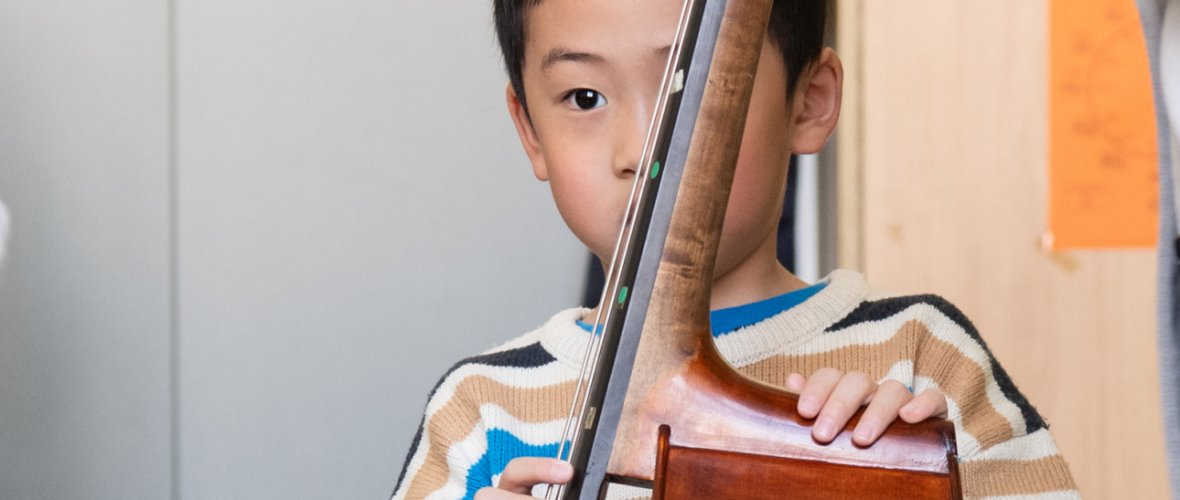 a boy holds a double bass