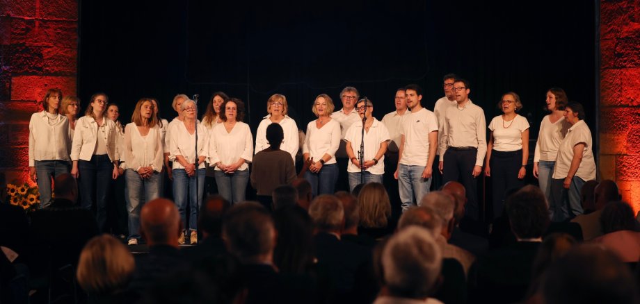 Choir sings on stage in the town hall