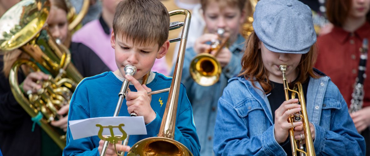 a group of young brass players plays