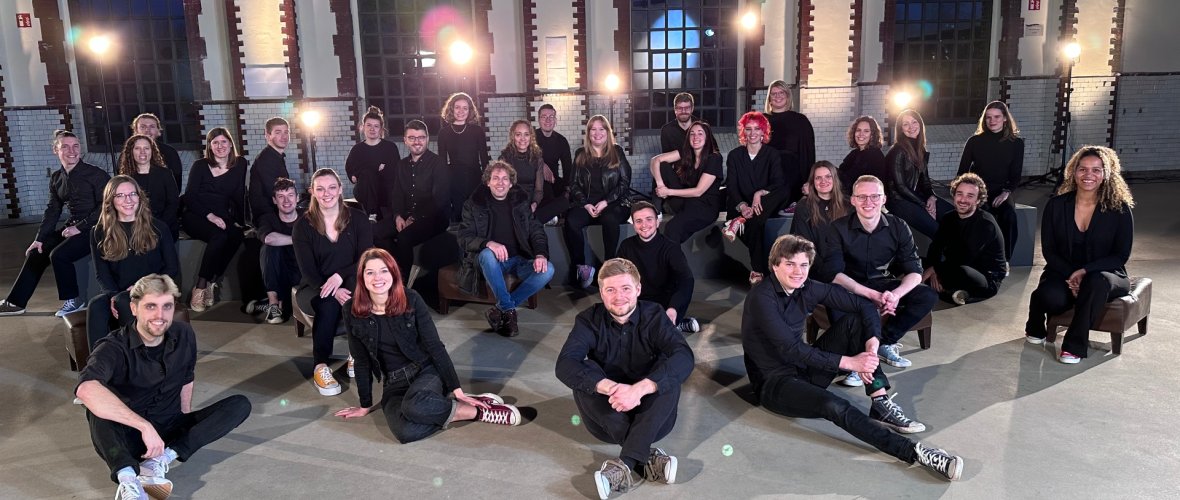 Cheerful ensemble picture in an industrial hall