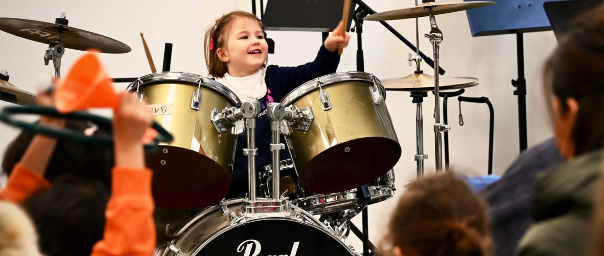 - a girl has fun playing the drums