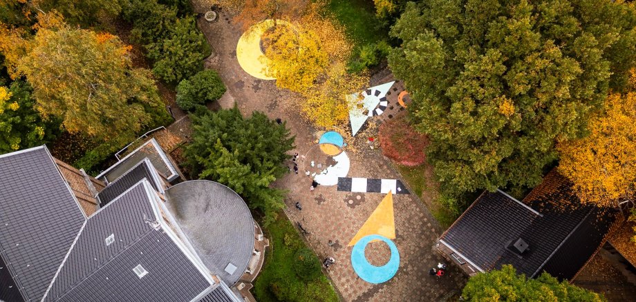 Aerial view of the finished square painting. Various shapes such as squares, triangles and circles in bright colors.