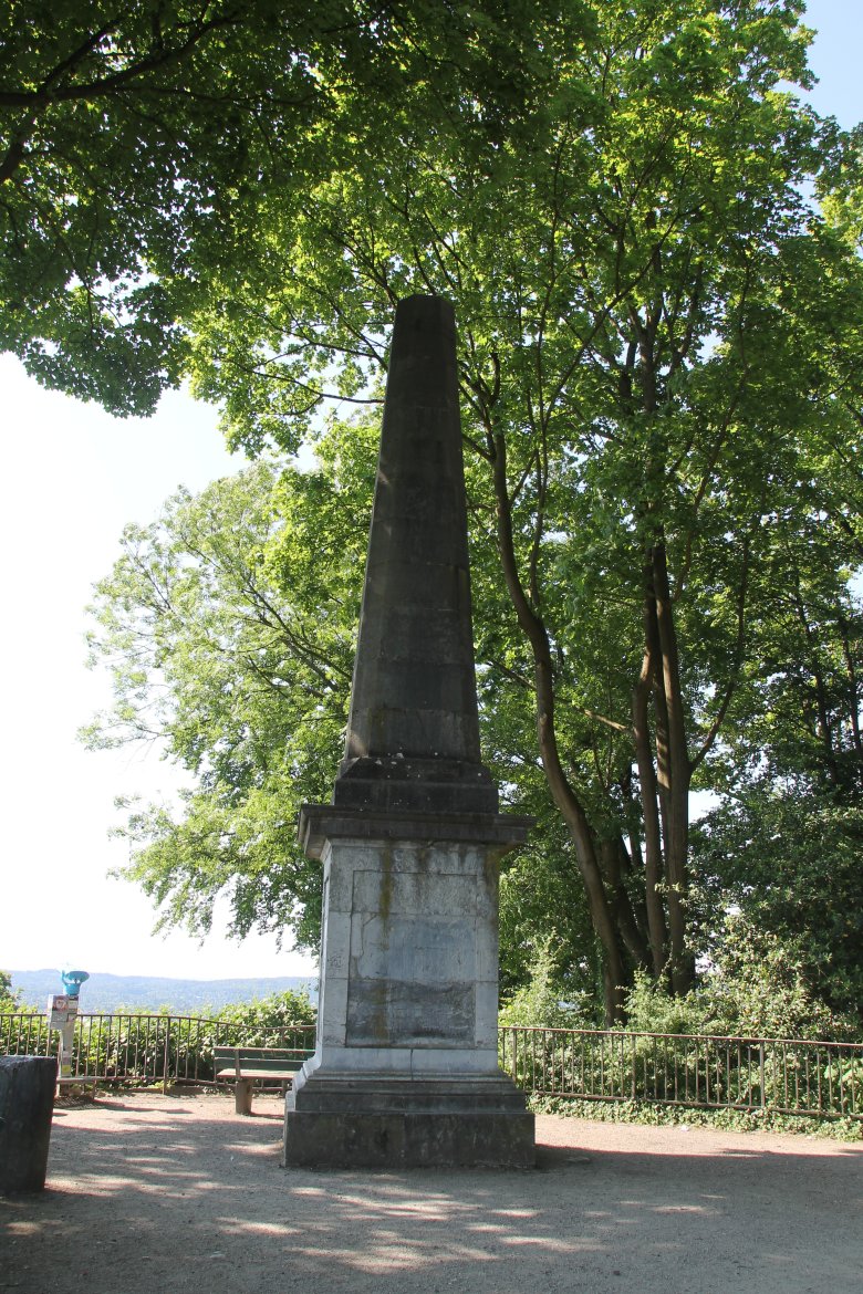 The obelisk on the Lousberg in sunlight. With trees in the background
