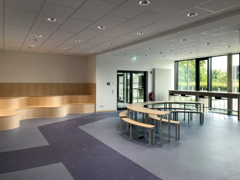 Gangolfsweg5_c_E26_2026_08 Multipurpose room on the ground floor with seating areas and an open study area