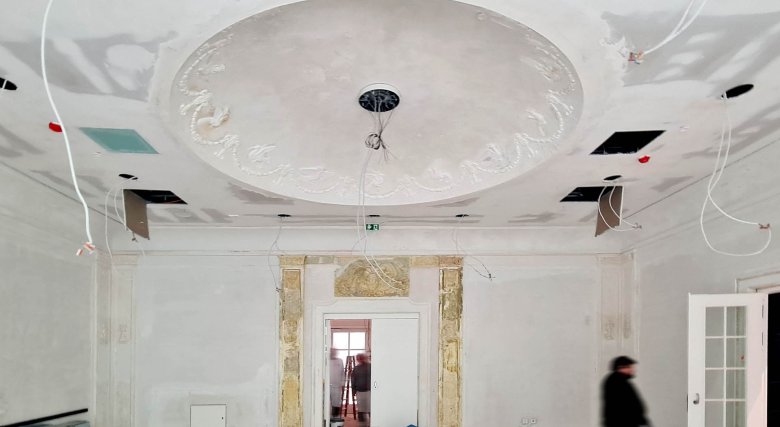 Partially exposed stucco in the former smoking foyer