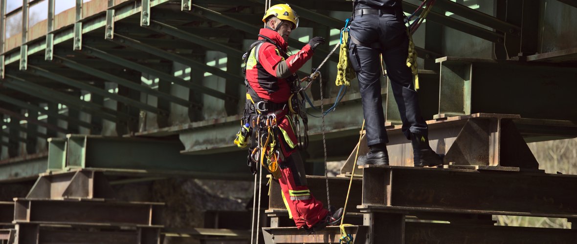 A fire officer candidate is trained in fall protection by a height rescuer on a steel lattice mast structure. The exercise was carried out on the Falkenbach viaduct.