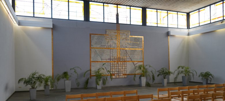Funeral hall with altar area in the background, rows of chairs in the foreground.
