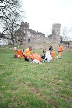Frankenburg clean-up campaign 4 people clearing away garbage on the meadow in front of the Frankenburg.