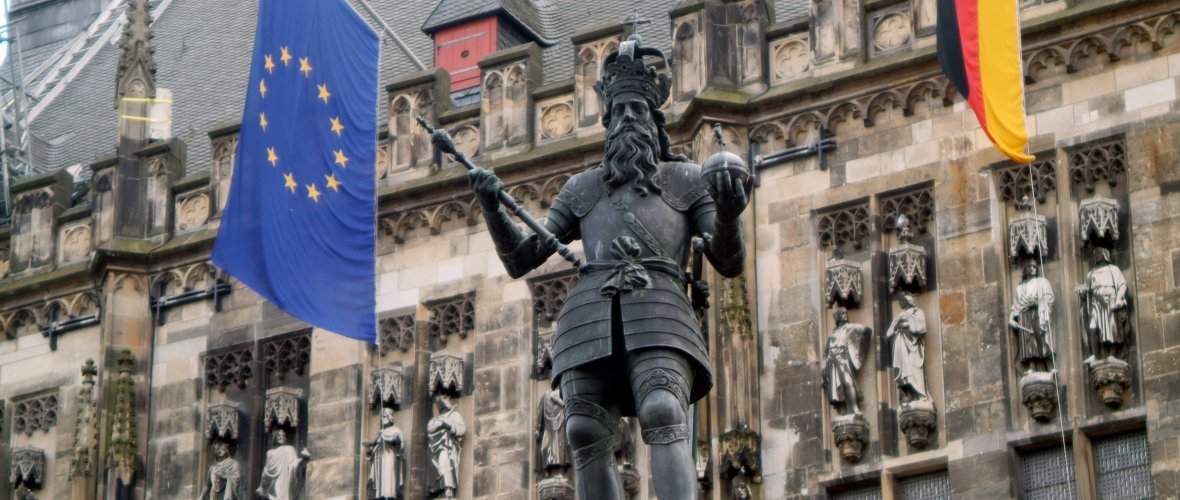 Emperor Charles on the Charles Fountain in front of the town hall with the European flag in the background.
