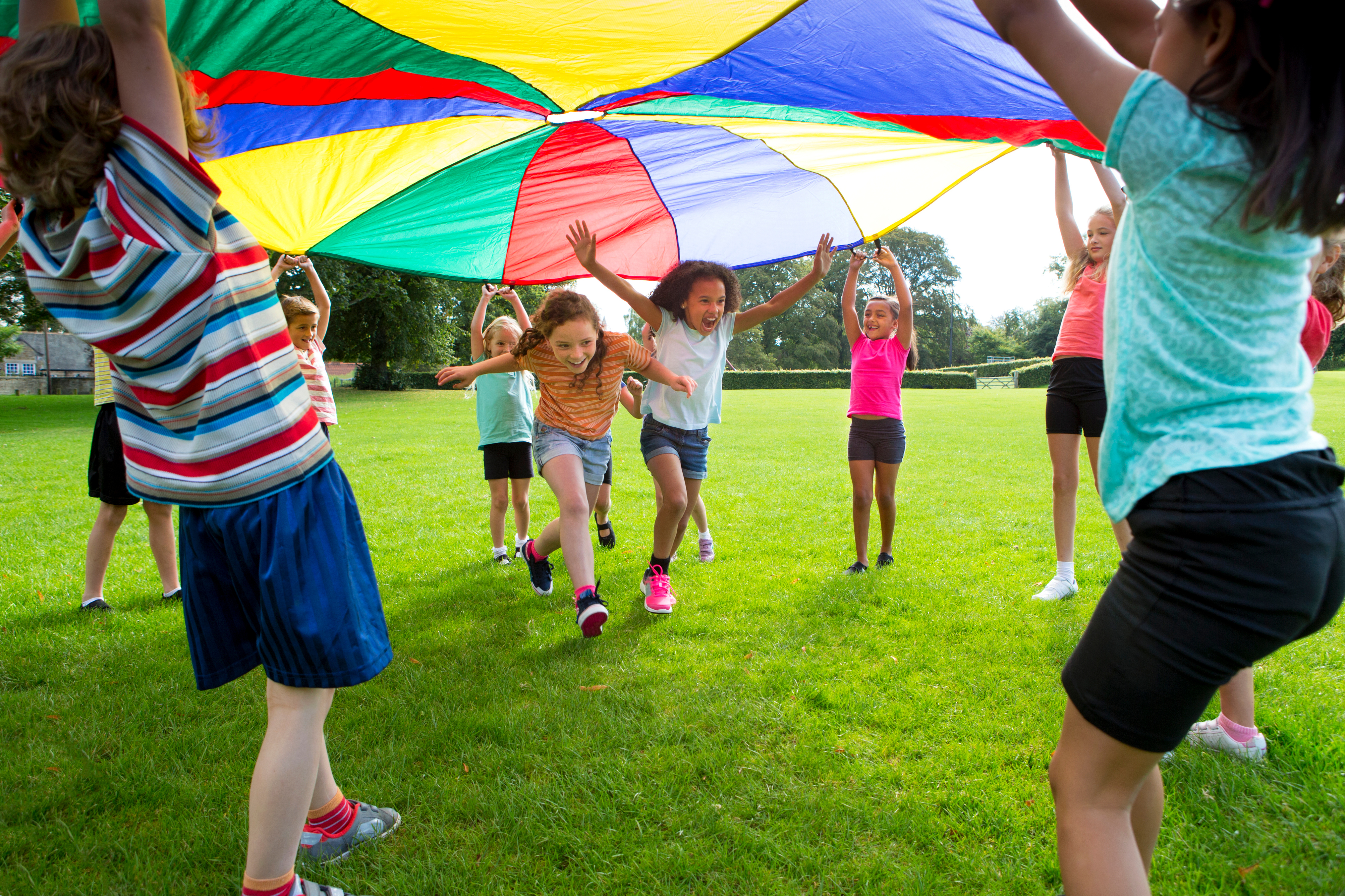 Outdoor Games Children play a game with a colorful parachute