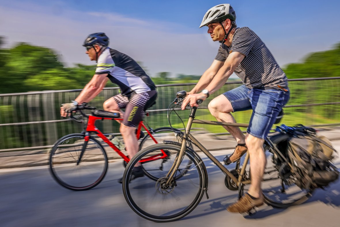 Two cyclists ride past quickly.