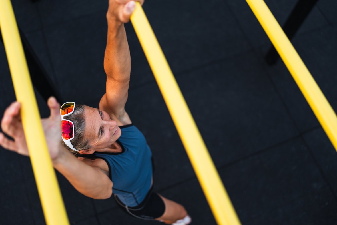 A woman climbs on a climbing frame.