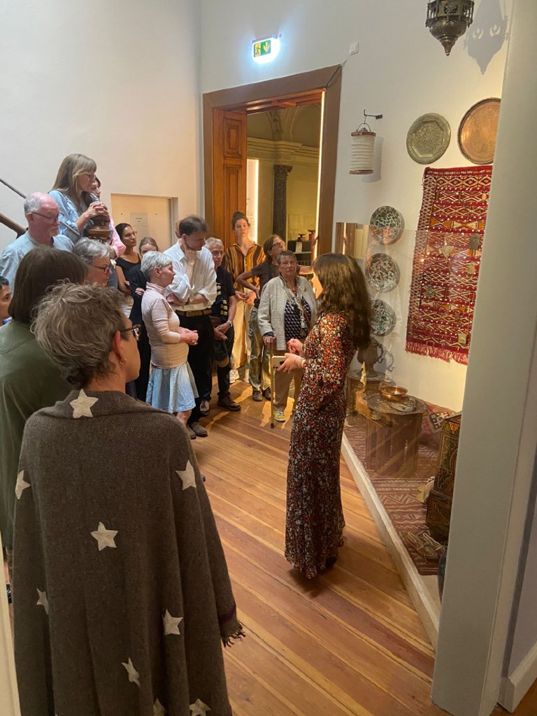 A woman explains an exhibition of Islamic art objects to a group of museum visitors