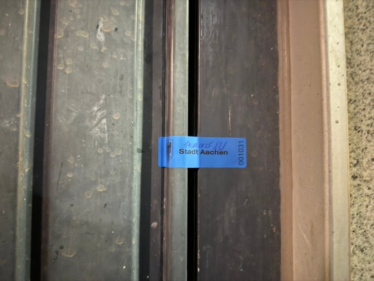 A municipal seal is stuck to a gate.