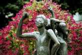 Le monument de Klenkes Monument de Klenkes. Trois statues avec le petit doigt levé. En arrière-plan, des fleurs roses