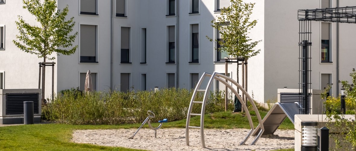 Maisons à plusieurs étages avec espaces verts et aire de jeux