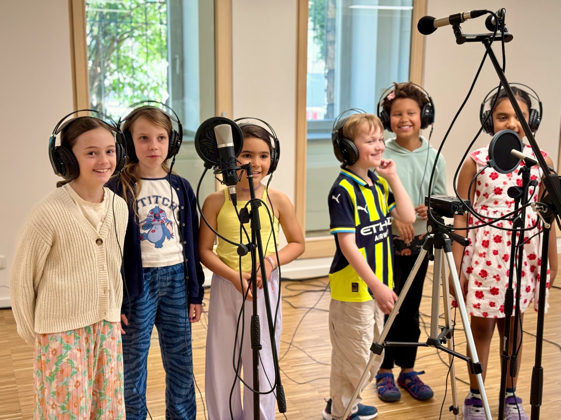 Des enfants avec des écouteurs dans un studio d'enregistrement