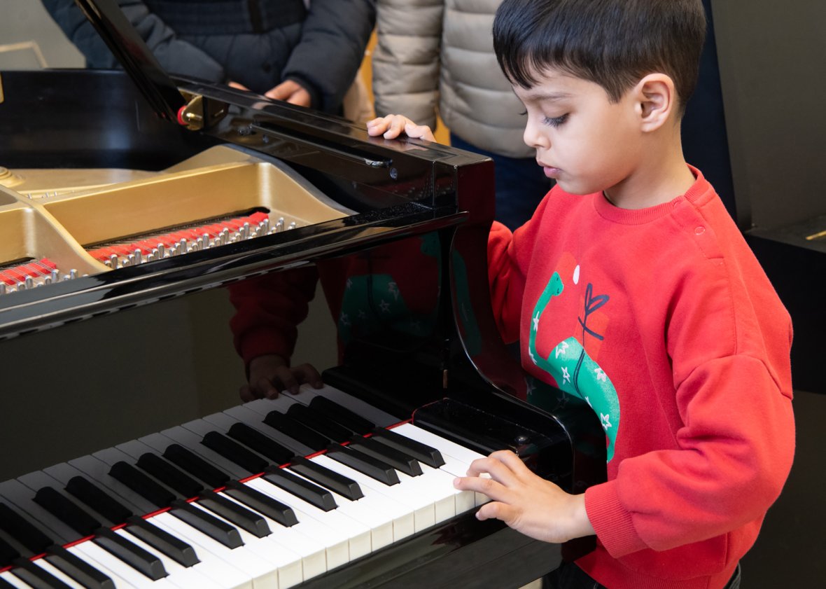 un garçon tape sur les touches d'un piano