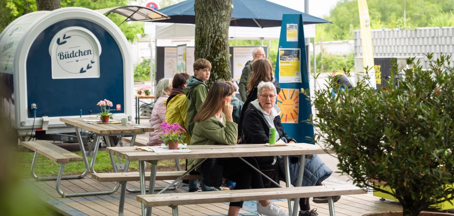 Deux personnes sont assises ensemble sur un banc en bois et discutent.