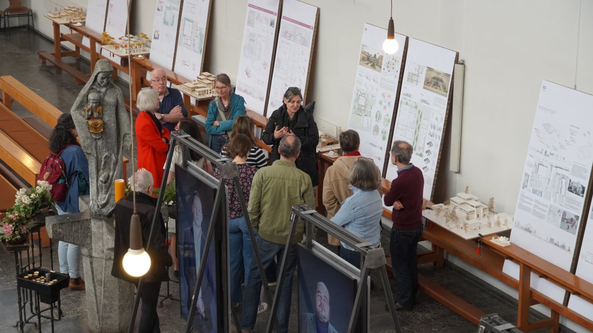 Visiteurs* d'une visite guidée des travaux d'étudiants, exposés dans l'église.