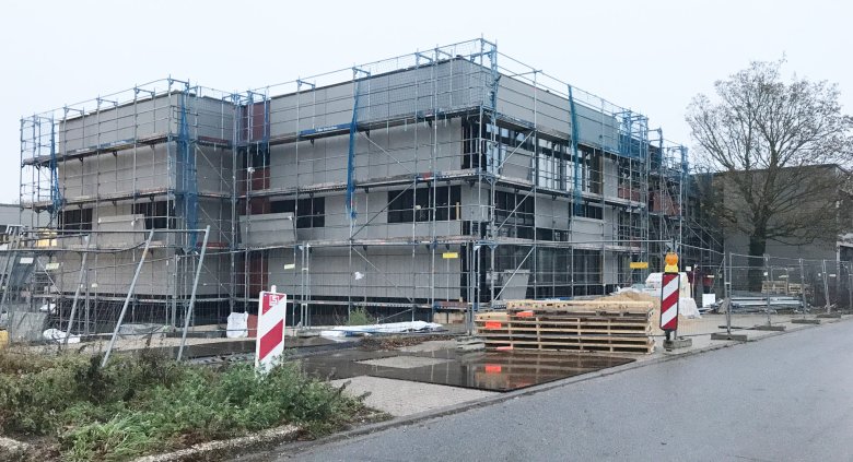 Les travaux de revêtement des murs-rideaux avec des panneaux en fibrociment sont en cours.