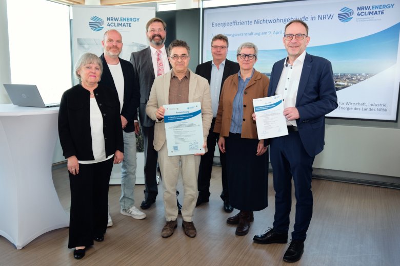 Prix_Breitbendenstraße_Gruppe1_c_NRW.Energy4Climate_GmbH_2025 Remise du prix, de gauche à droite : Gabriele Hajok (responsable du service de gestion des bâtiments), Christoph Salentin (PBS-Architekten Aachen), Jens Hausschild (responsable de l'entreprise de gestion des bâtiments), Leonidas Papadopoulos (responsable du projet de gestion des bâtiments), M. Petersdorff (ministère MWIKE NRW) Silke Krebs (secrétaire d'État du ministère MWIKE NRW), Heiko Thomas (département Environnement de la ville d'Aix-la-Chapelle).