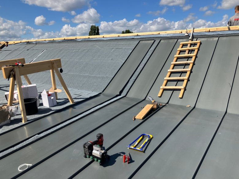 Les travaux de zinguerie sur le toit avancent.