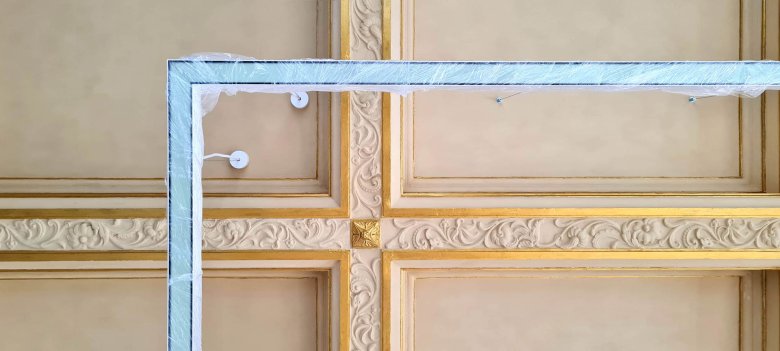 Le nouvel élément d'éclairage linéaire devant le plafond doré mis à nu dans l'une des plus petites salles