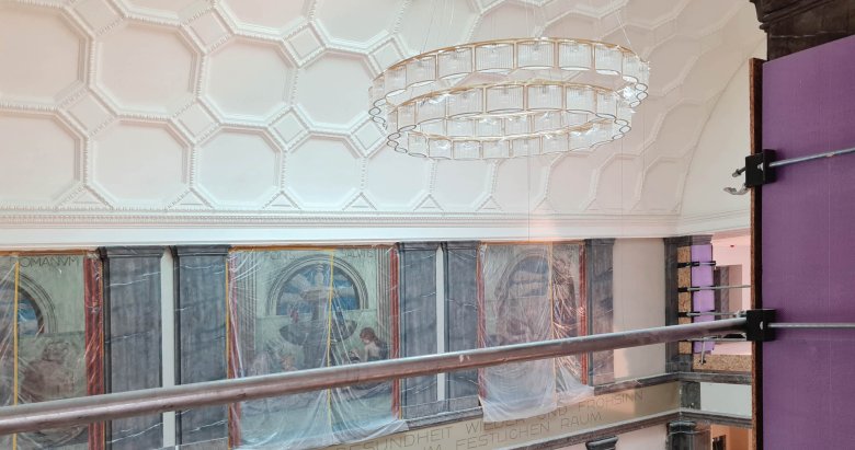 Vue du hall d'entrée depuis l'étage supérieur avec les peintures murales et le chandelier