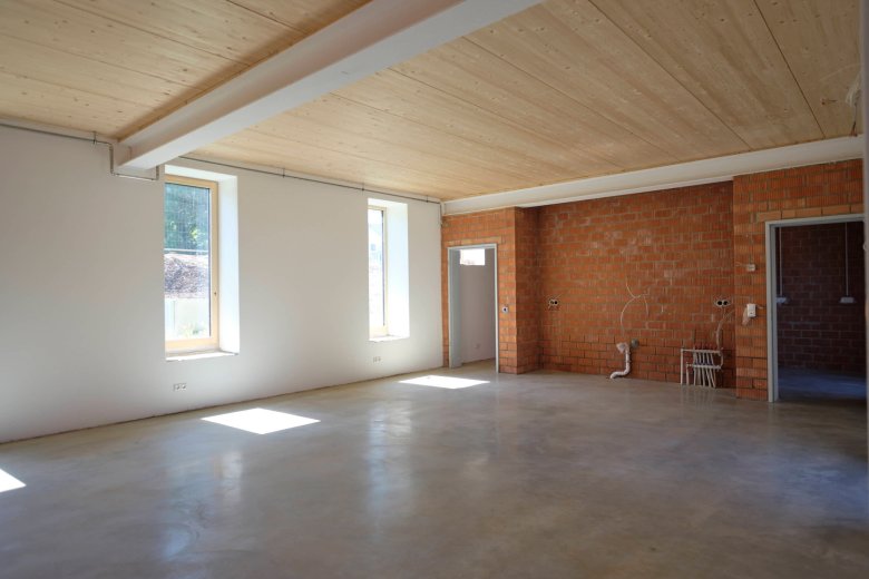 L'atelier dans l'ancienne écurie avec un faux plafond encastré et un enduit d'isolation thermique.