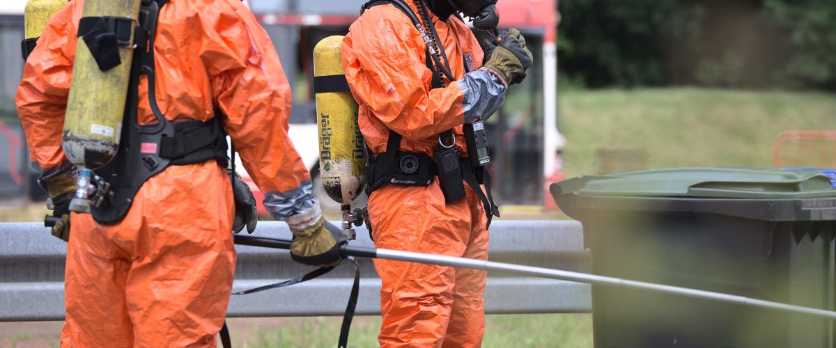 Pompiers sous vêtements de protection avec une sonde de mesure pour détecter les radiations atomiques