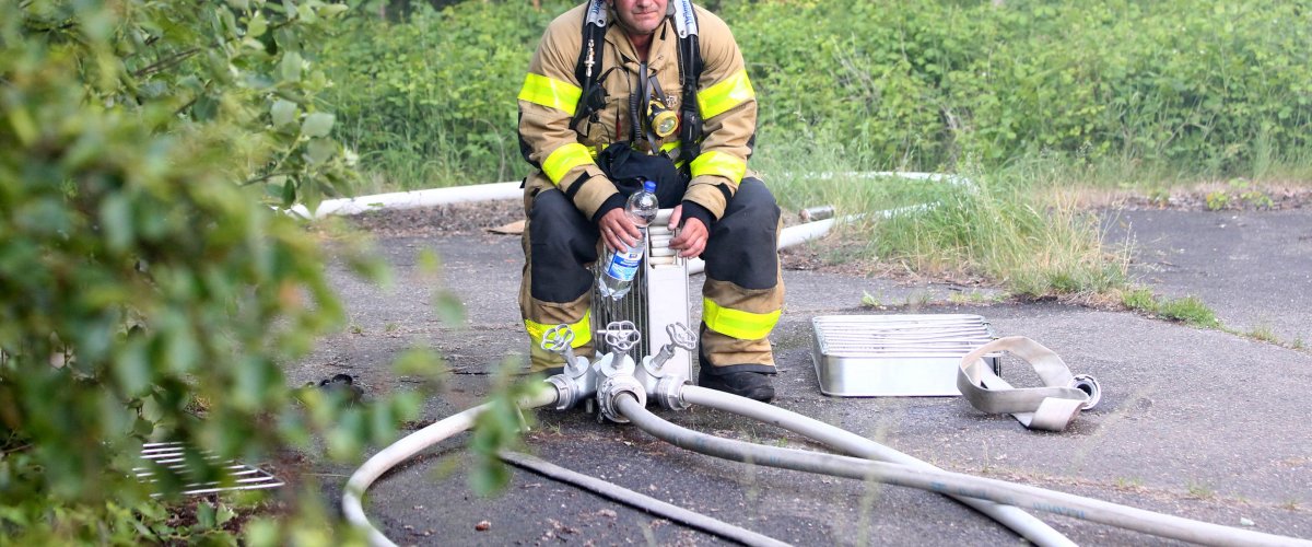 Certaines interventions s'étendent sur plusieurs heures.  Les vêtements de hip-hop sont extrêmement chauds et sous protection respiratoire, chaque mouvement est difficile. Un collègue se repose un instant, boit de l'eau et essaie de reprendre des forces.