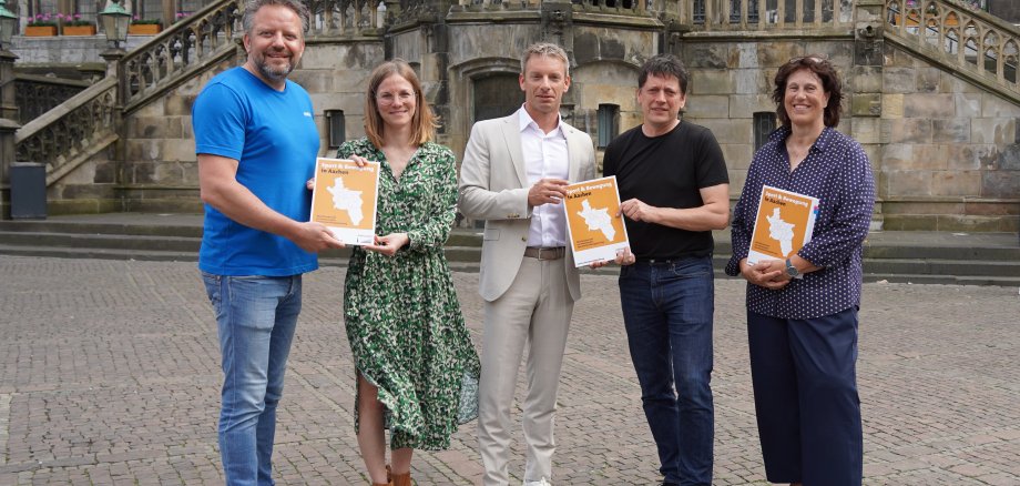 Présentent ensemble le nouveau plan de développement du sport pour Aix-la-Chapelle : Björn Jansen, président de l'association sportive de la ville d'Aix-la-Chapelle, Dr Julia Thurn, Institut de planification coopérative et de développement du sport, Dr Markus Kremer, conseiller municipal en charge des sports, Dr Sebastian Breuer, président du comité des sports de la ville et Petra Prömpler, directrice du département des sports de la ville d'Aix-la-Chapelle (de gauche à droite).