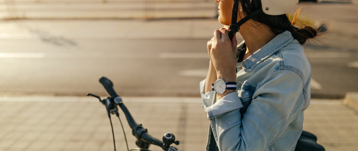 Une femme ferme son casque de vélo.