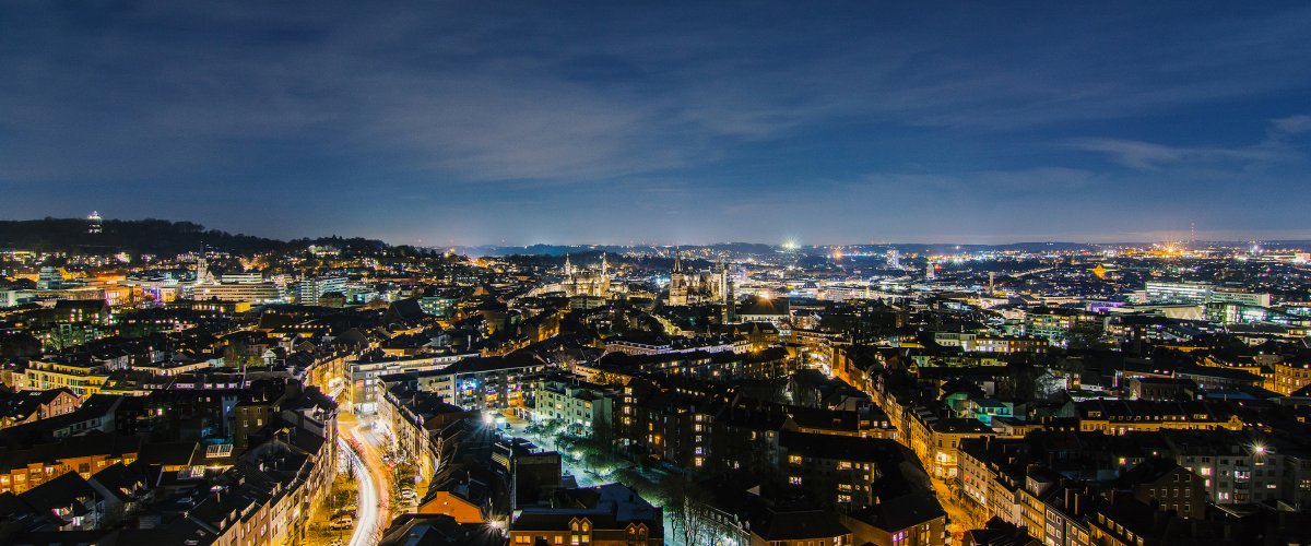 Belle photo de nuit d'Aix-la-Chapelle avec des lumières scintillantes en direction de l'église Saint-Jacques.