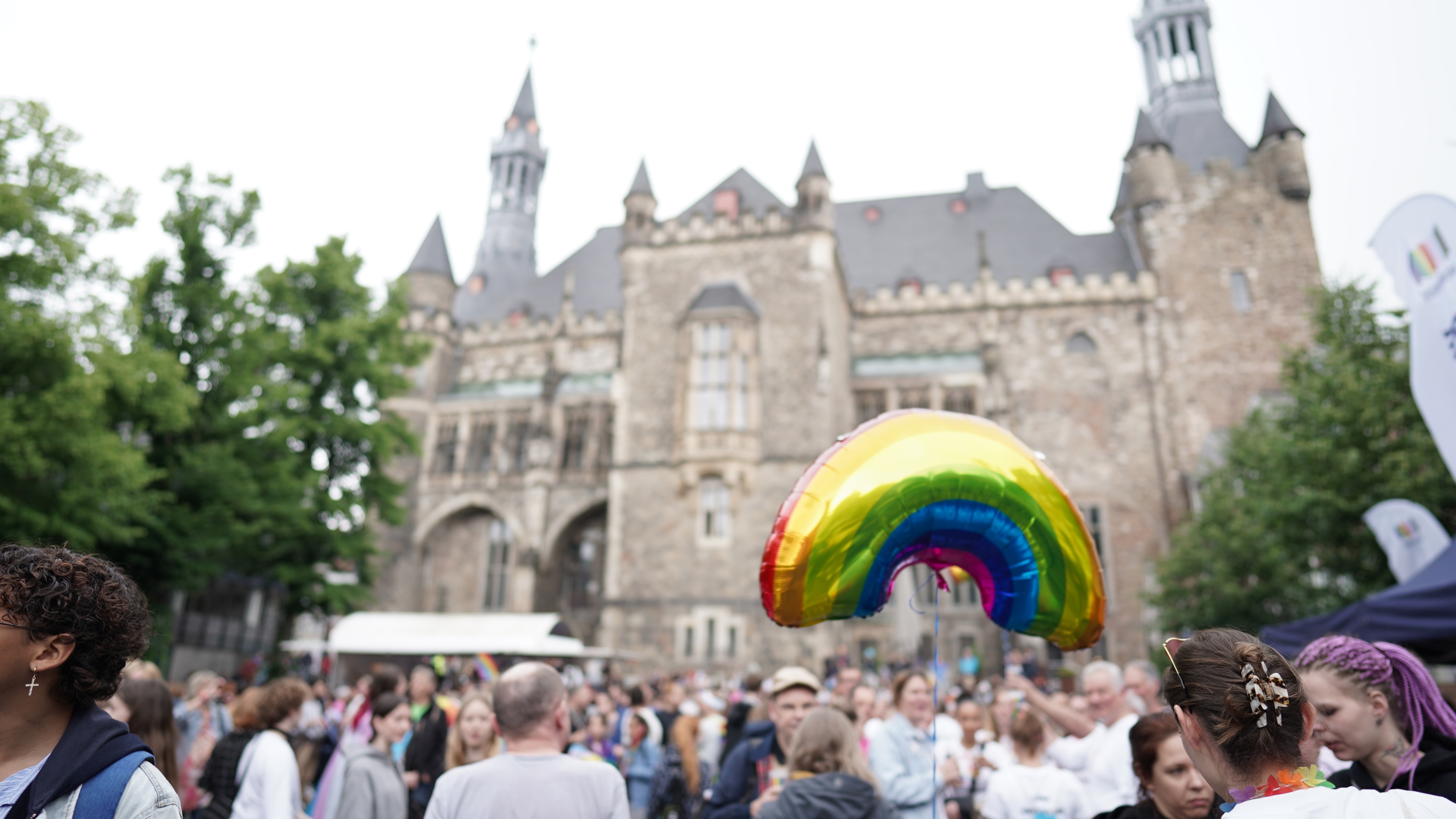 Foule sur le Katschhof. En point de mire, un ballon aux couleurs de l'arc-en-ciel. En arrière-plan, la mairie.