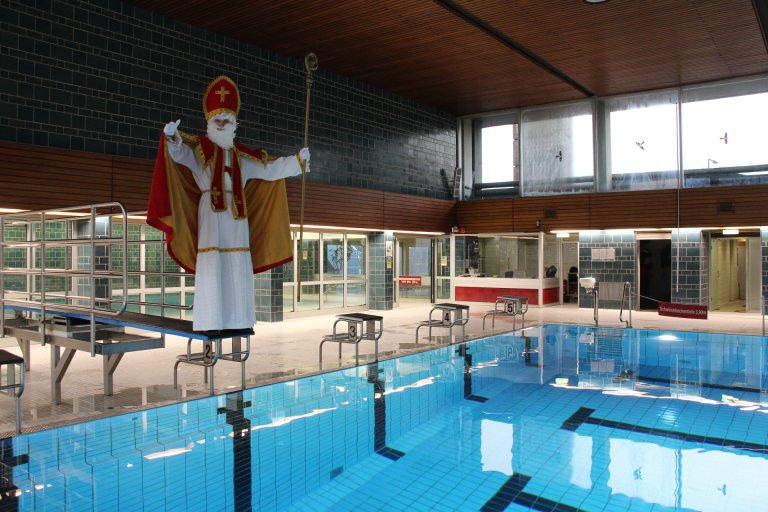 Saint Nicolas se tient sur un plongeoir au-dessus de l'eau dans la piscine couverte de Brand.