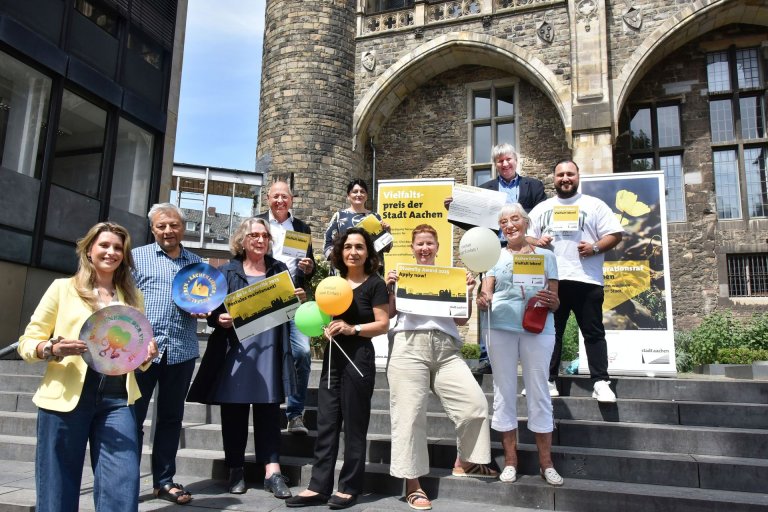 Un groupe de personnes se tient sur les marches de la cathédrale, tenant en l'air des informations sur le prix du pliage de VI.