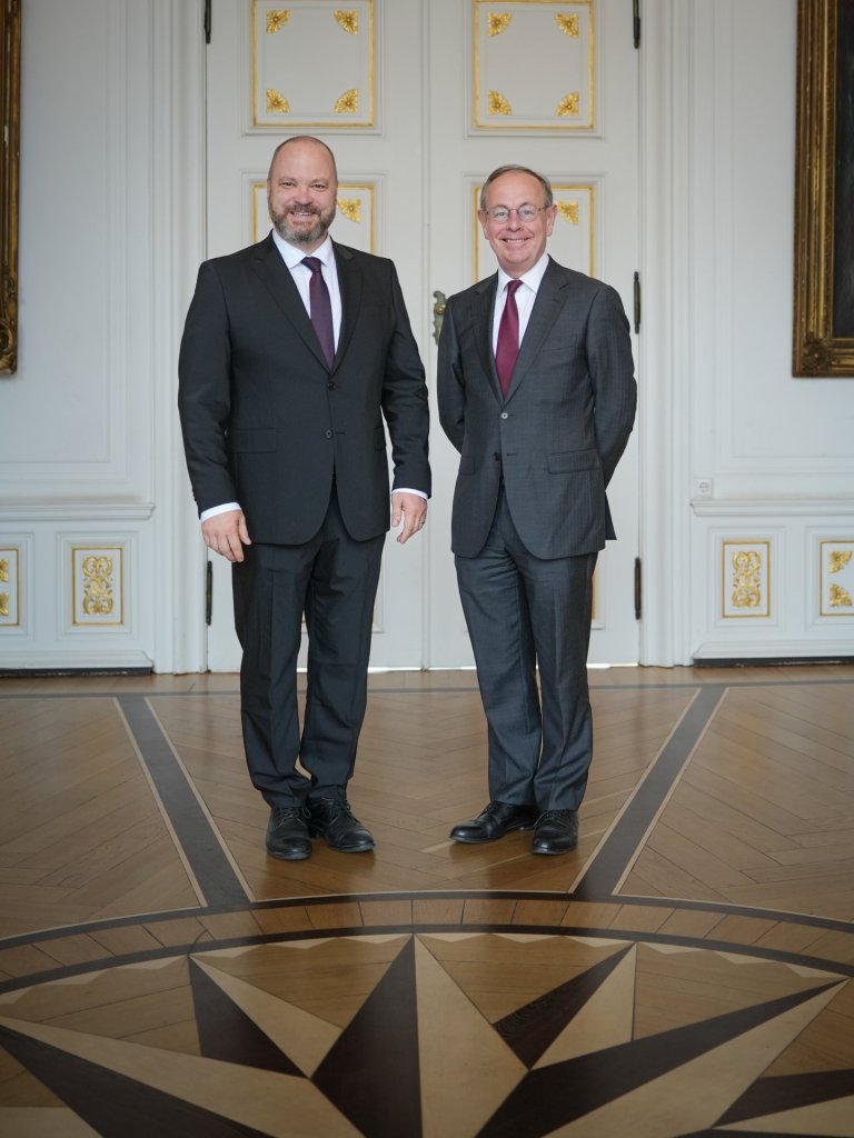 Le maire Michael Ziemons et le directeur de l'UE Patrick Child se tiennent dans la salle blanche de l'hôtel de ville.
