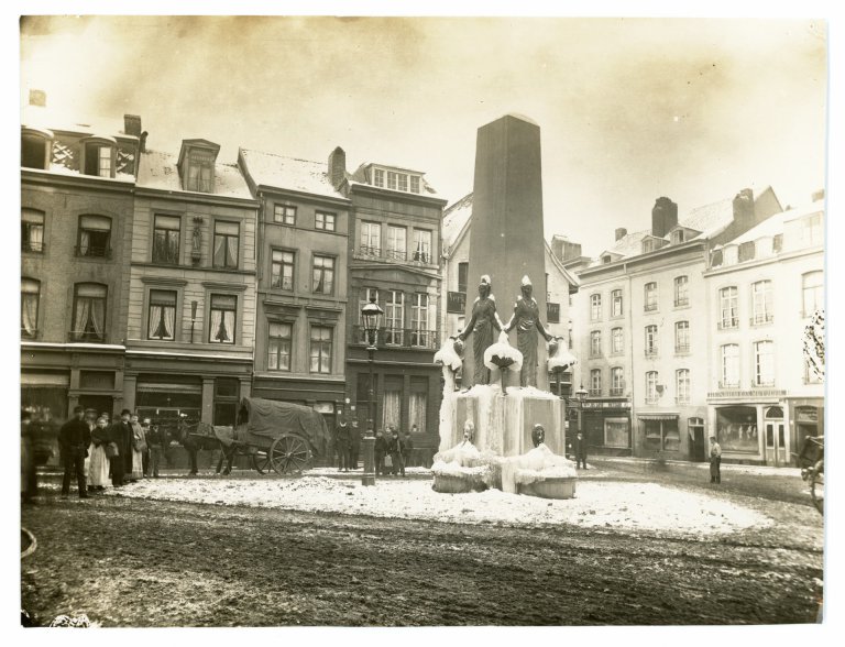 On voit la vue sur la Alexanderstraße enneigée en direction de Sandkaulbach. Au centre gauche de l'image, on peut voir les bâtiments Alexanderstraße 9 à 17. Devant les maisons se trouve le Hotmannspief, à côté un chariot à chevaux et des passants. Au milieu de l'image, à droite, on peut voir l'embouchure du Sandkaulbach et les bâtiments Sandkaulbach 27 à 33.