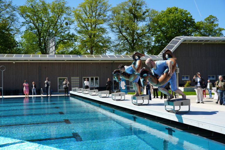 Deux hommes sautent dans une piscine