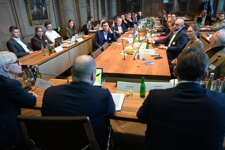 Les gens se parlent dans la salle du conseil municipal d'Aix-la-Chapelle.