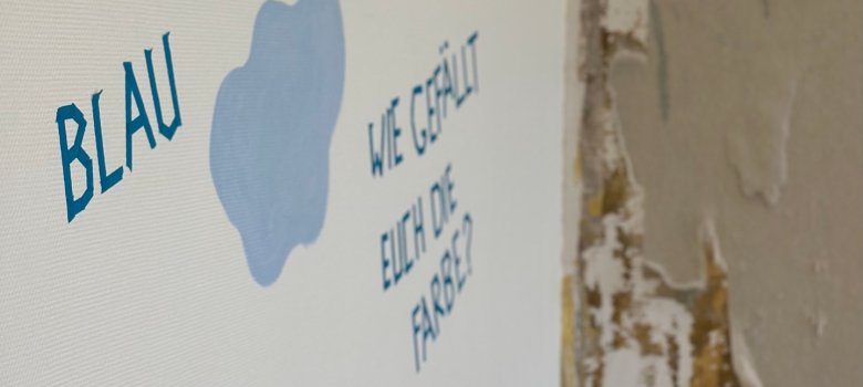 Op de muur staat: "Blauw - wat vind je van de kleur?"