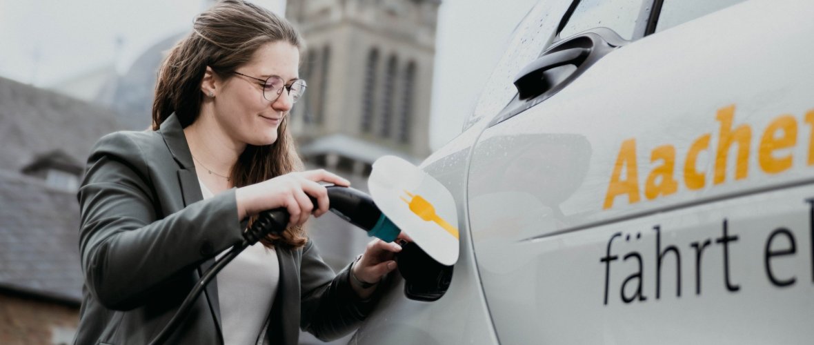 Vrouw laadt e-auto op Vrouw laadt e-auto op