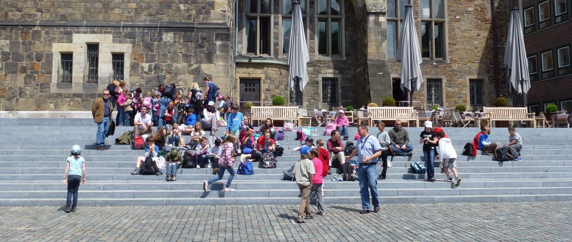 Kinderen zitten op de trap voor het stadhuis