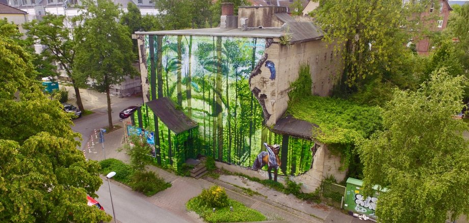 Luchtfoto van het voltooide kunstwerk. Je ziet een graffiti met bomen en dieren.